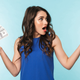 A woman throwing her hands up and clutching money.